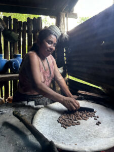 Local guide preparing cacao beans during hands-on chocolate making experience in Guatemala