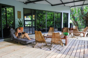 Riverfront terrace with lounge seating and jungle views at Isla Mujeres female dorm