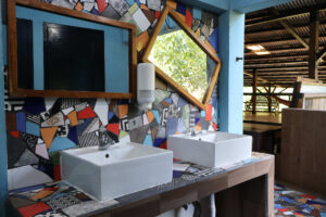 Shared bathroom sinks with artistic decor in the Noisy Dorm at Greengo’s Guatemala