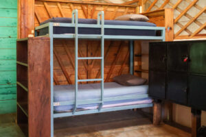 Wooden bunk beds and locker storage inside the lively Noisy Dorm at Greengo’s Guatemala