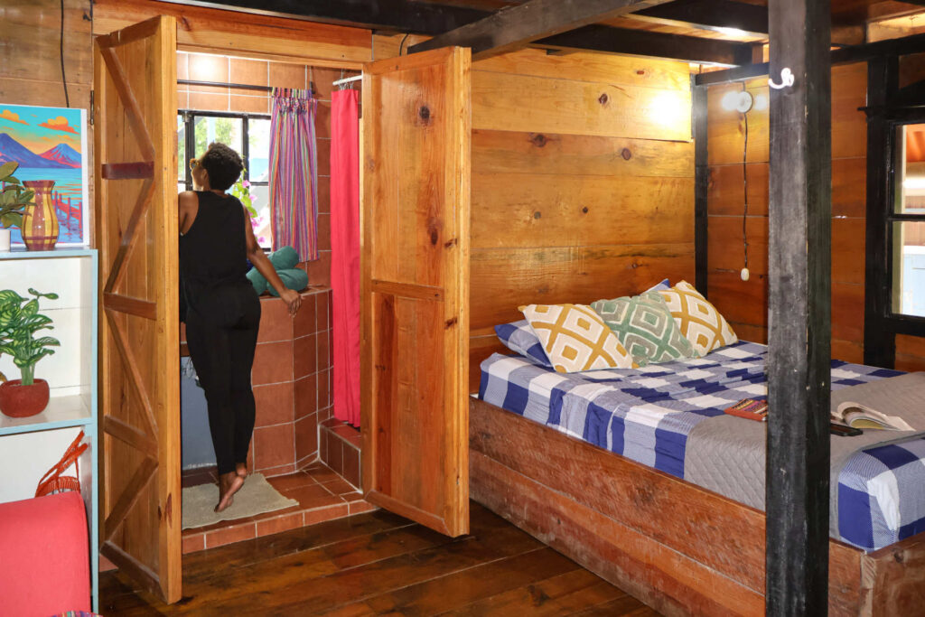 Spacious private guest room featuring rustic wooden details and tropical garden views at Greengo's Hotel, Lanquin.