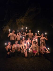 Travel group posing with candles during K’anba Cave Tour adventure in Guatemala