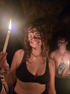 Traveler holding candle inside K’anba Cave during underground river tour adventure