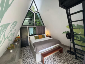 King bed inside Garden Cabaña with mountain-view loft and modern jungle design