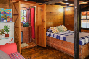 Rustic Riverside Room with private bathroom and wooden jungle-style interior at Greengo’s