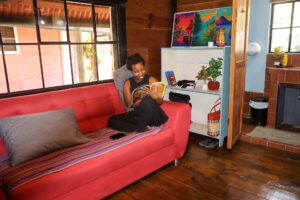 Guest relaxing inside Riverside Room with riverfront balcony access