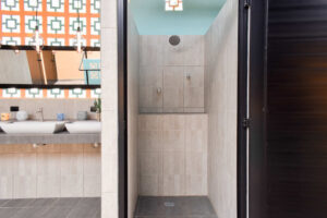 Private shower stalls and shared bathroom facilities in El Barrio complex