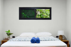 Queen room in El Barrio with modern design and custom wooden storage at Greengo’s