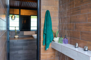 Shared bathroom with open-air shower and modern design in Nomads accommodations