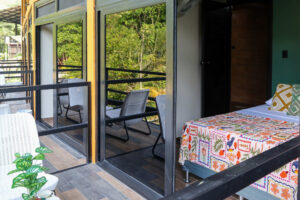 Nomads room with double bed and sliding doors opening onto a jungle-view balcony