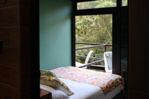 Double bed in Nomads semi-private room with sliding glass doors and balcony access