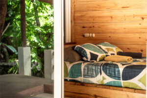 Double bed and balcony view inside Cozy Nook semi-private room with jungle charm