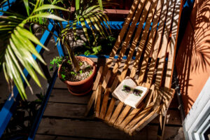 Balcony seating area surrounded by tropical plants at PoolFront Loft cabaña
