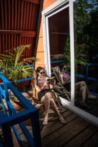 Guest relaxing on private balcony outside PoolFront Loft at Greengo’s Hotel
