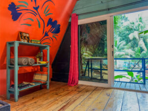 Double queen loft room with balcony and vibrant jungle-style interior design