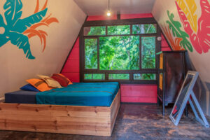 King bed inside bright PoolFront Loft with jungle views and wooden cabaña design