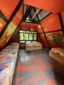 Spacious quadruple loft room with colorful interior and shared bathroom access at Greengo’s