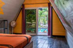 Queen loft room with pool-view balcony and large jungle-facing windows