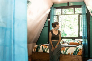 Queen bed loft room with large jungle-view windows in PoolFront Lofts at Greengo’s